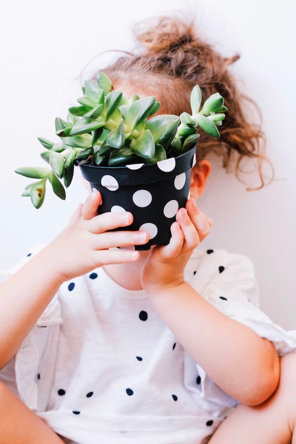 niña jugando con planta